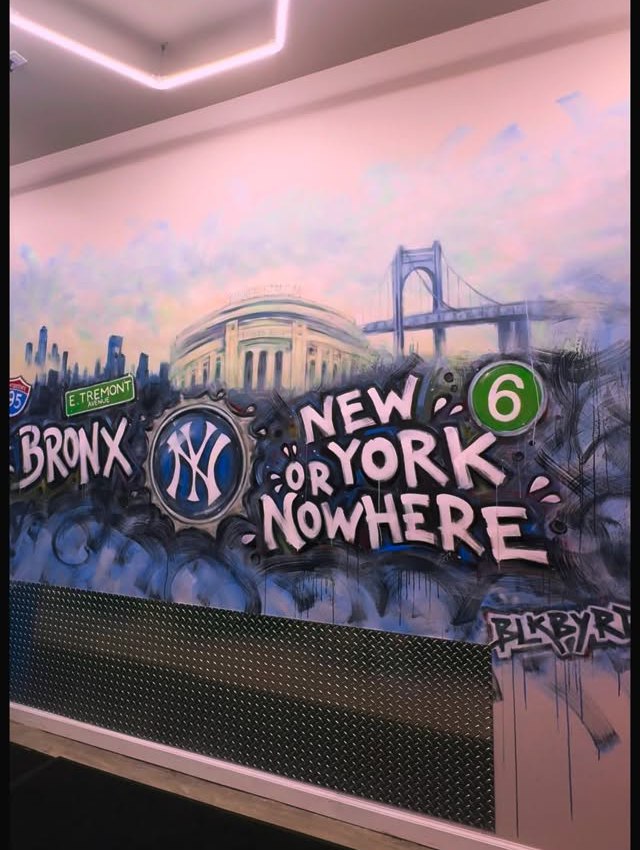 The shop's painted wall reading Bronx, New York or Nowhere with the Yankees mark, the 6 train and the bridge