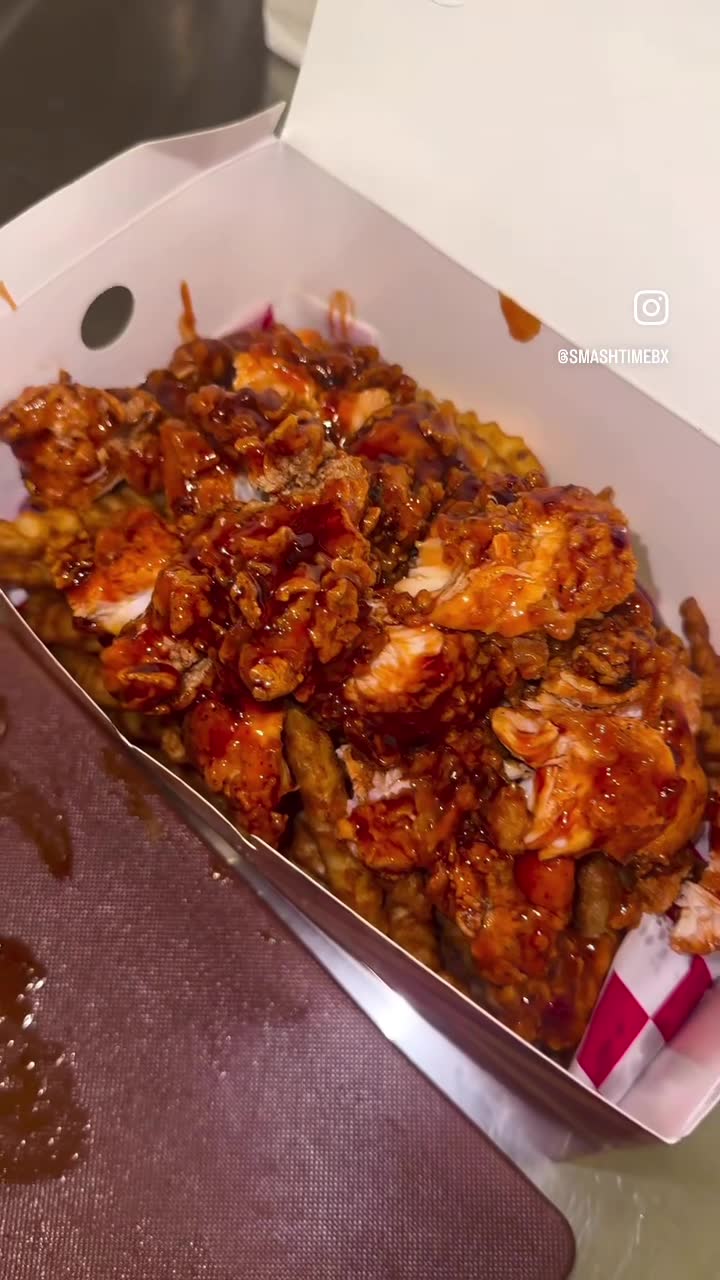 Waffle fries with fried chicken and a red sauce